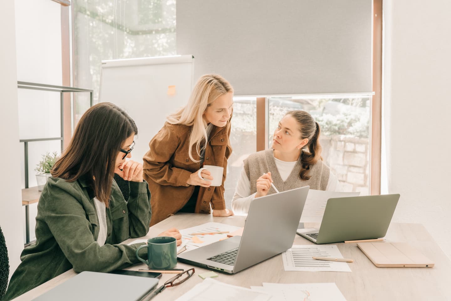 Three people in a deep discussion, working together at an office table